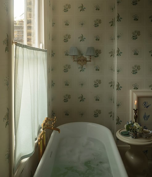 Linnaeus Original Wallpaper in bathroom with a bathtub table and candle