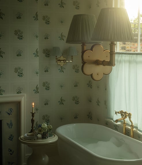Linnaeus Original Wallpaper in bathroom with a bathtub table and candle