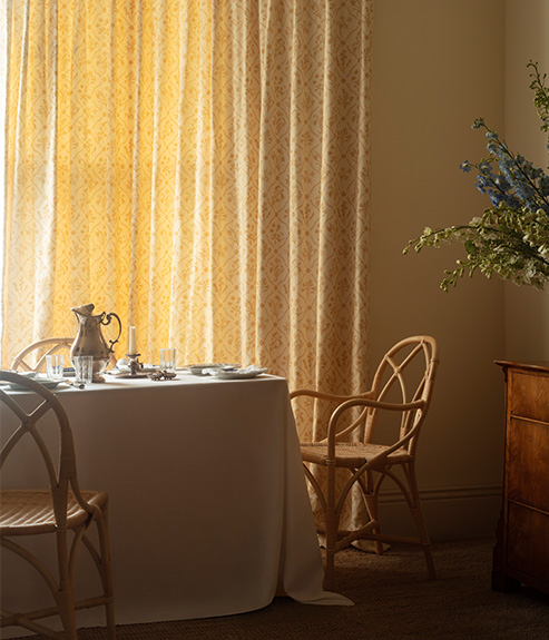 Lucknawi Flower Straw large curtains behind dinner table and rattan chair 