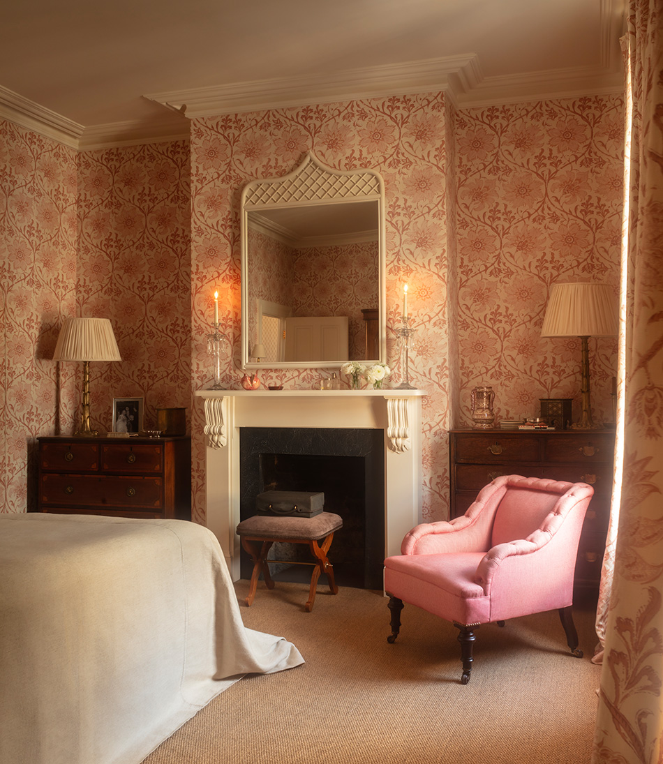Mole Chestnut upholstered stool in a pink bedroom with a fireplace and large white mirror