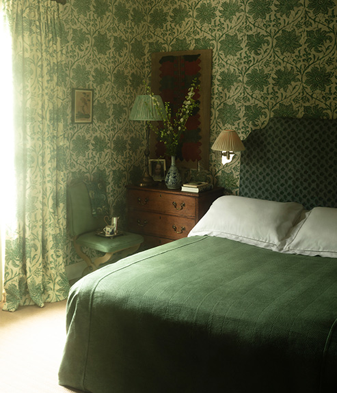Palampore Blossom Emerald in a bedroom with green bed