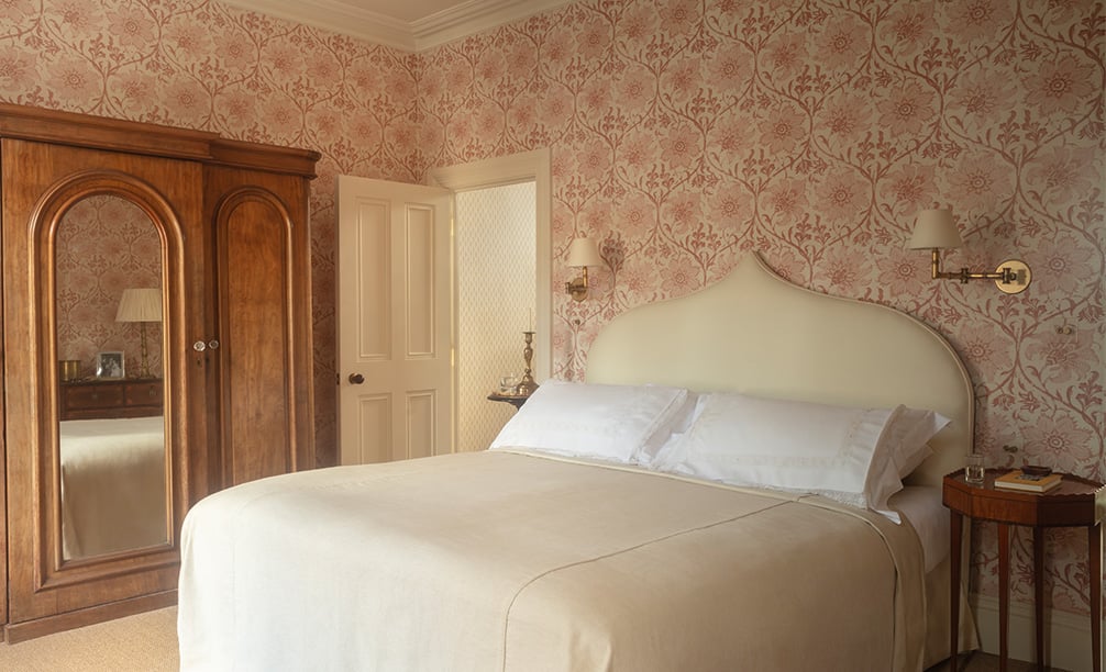 Palampore Blossom Indian Pink wallpaper in a bedroom
