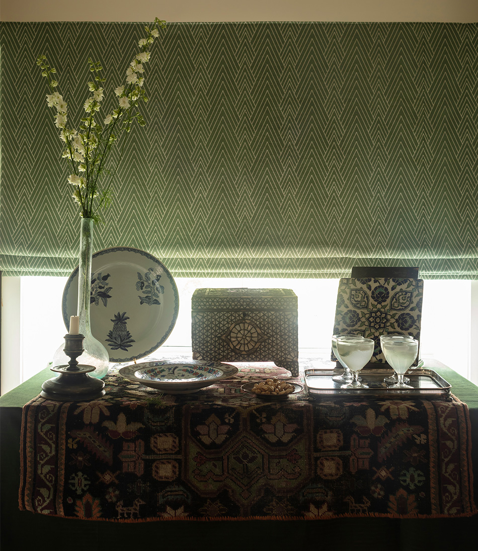 Philae Eau De Nil on a blind in front of a chest with multiple antiques 