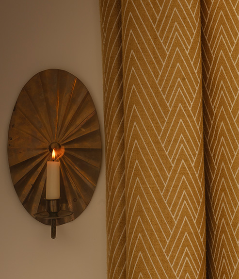 Philae Old Gold curtains next to a antique Brass lamp