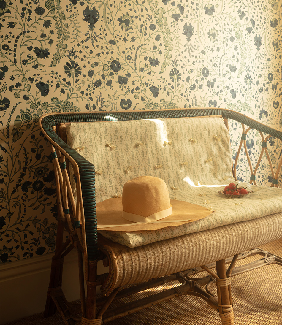Serpentine Fern Duck Egg Blue cushion on an antique rattan bench
