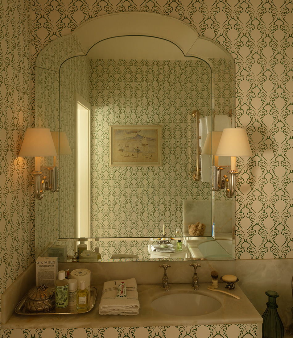 The Card Shade 7" for osh bulb on a wall light with green wallpaper in a bathroom 