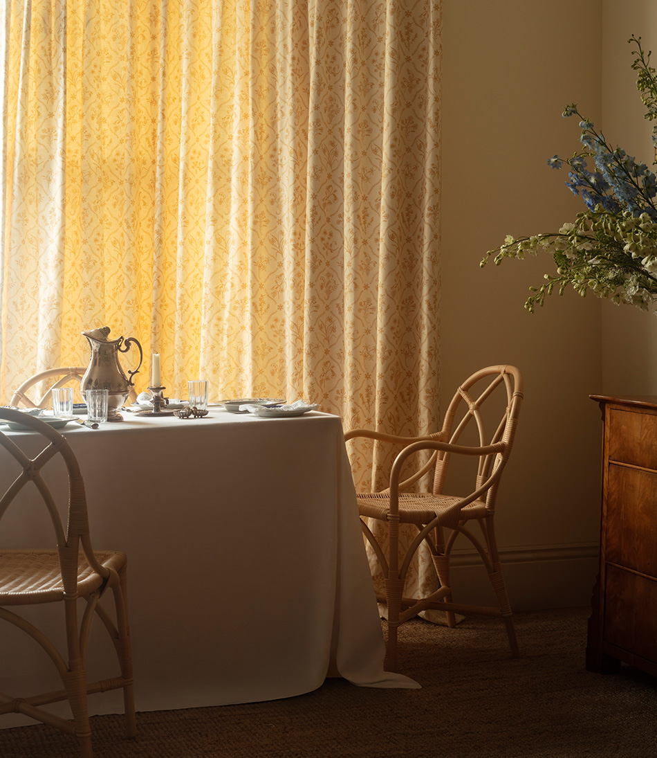 The Dryad whalebone with arm at a dinner table with long heavy curtains