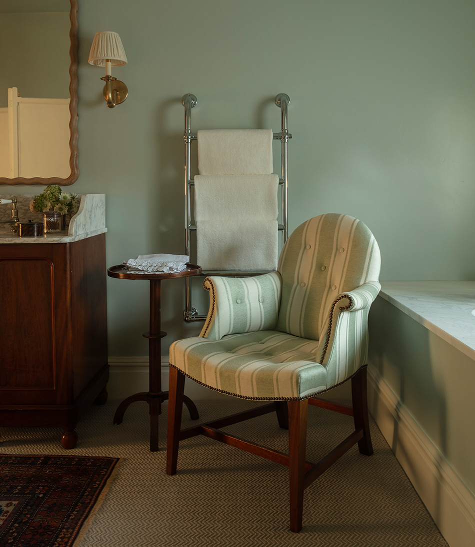 The Moonback chair in Blue and white fabric in a bathroom with the wave mirror 