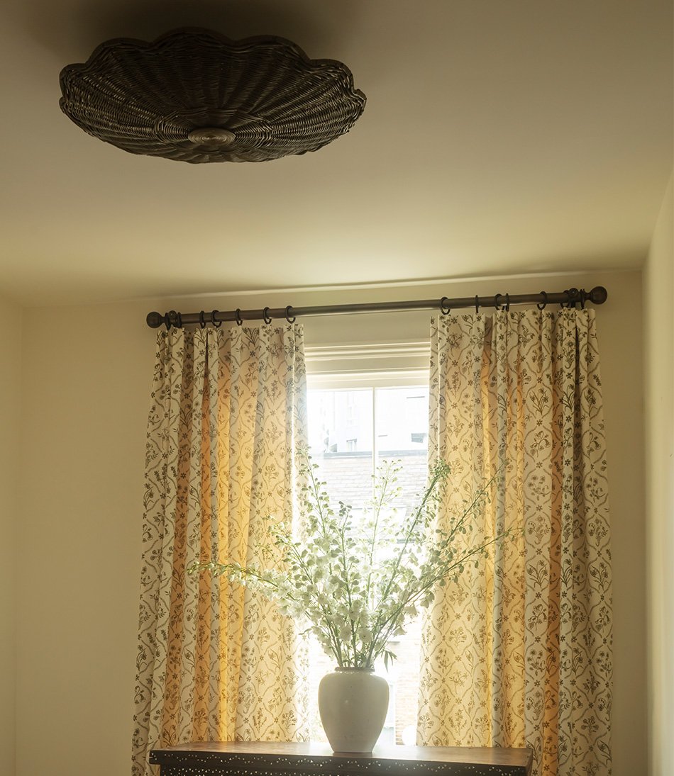 The Rattan Scallop Flush Ceiling Light Large with a pair of green and white curtains and a large vase of flowers