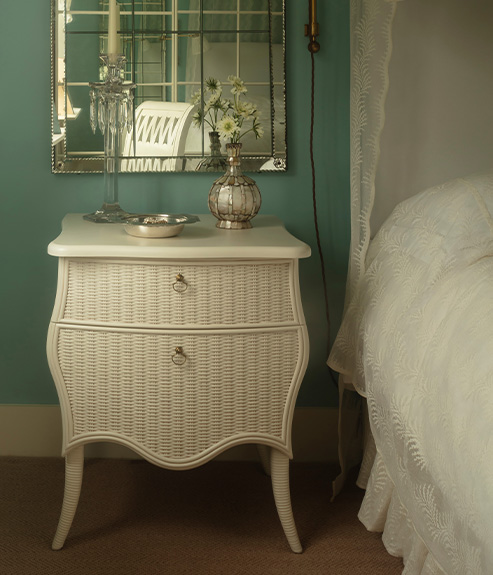 The Virginia Chest in a blue bedroom with a glass segmented mirror and lace curtains 