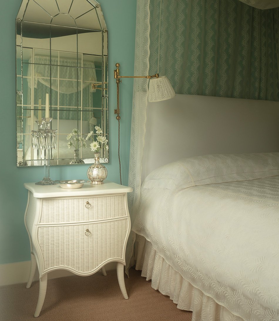 The Virginia Chest in a blue bedroom with a glass segmented mirror and lace curtains 